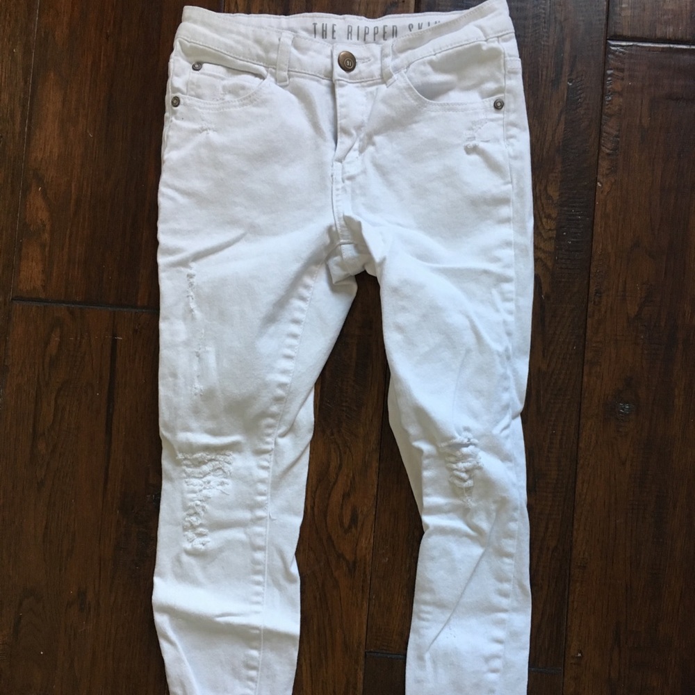 Skinny white distressed jeans with raw hem